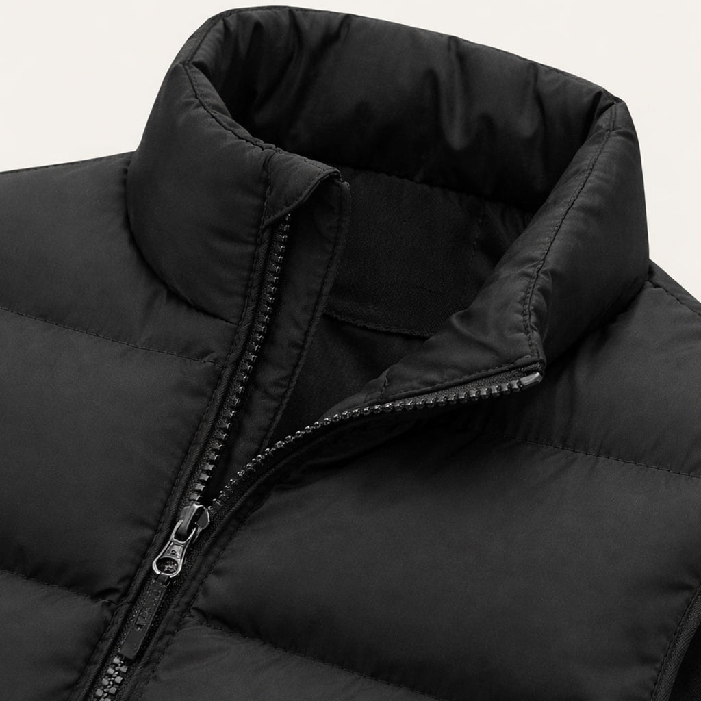 Black padded puffer vest close-up of stand collar and zip fastening