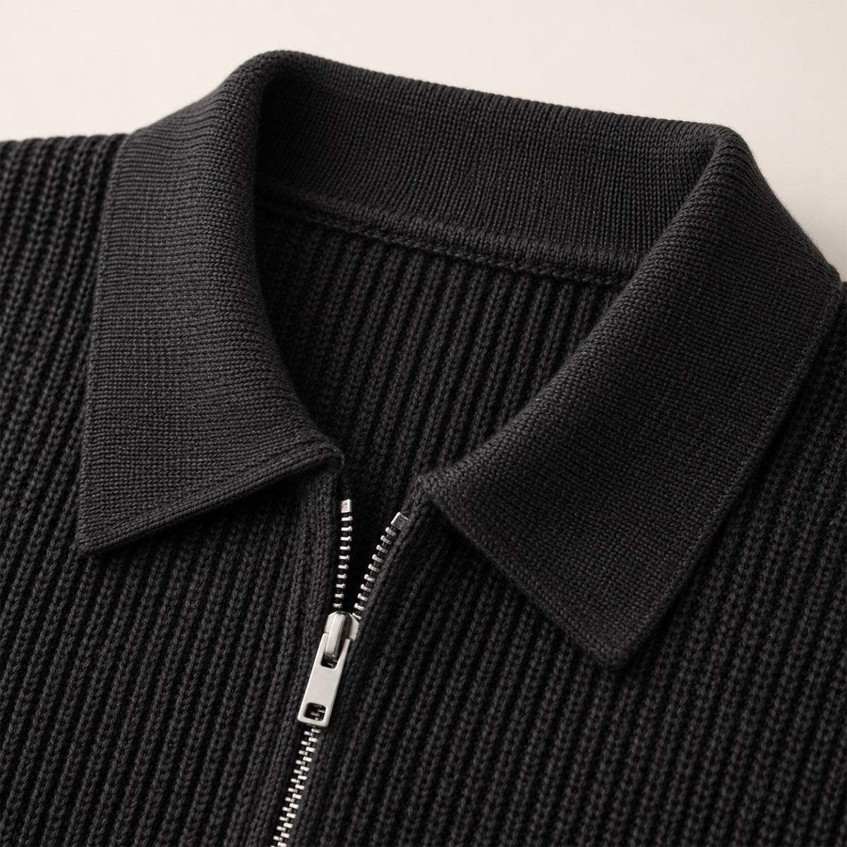 Black half-zip knit sweater detail with ribbed collar and exposed zipper.