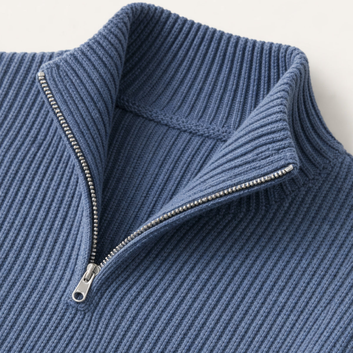 Navy blue half-zip sweater detail with metal zipper and ribbed collar