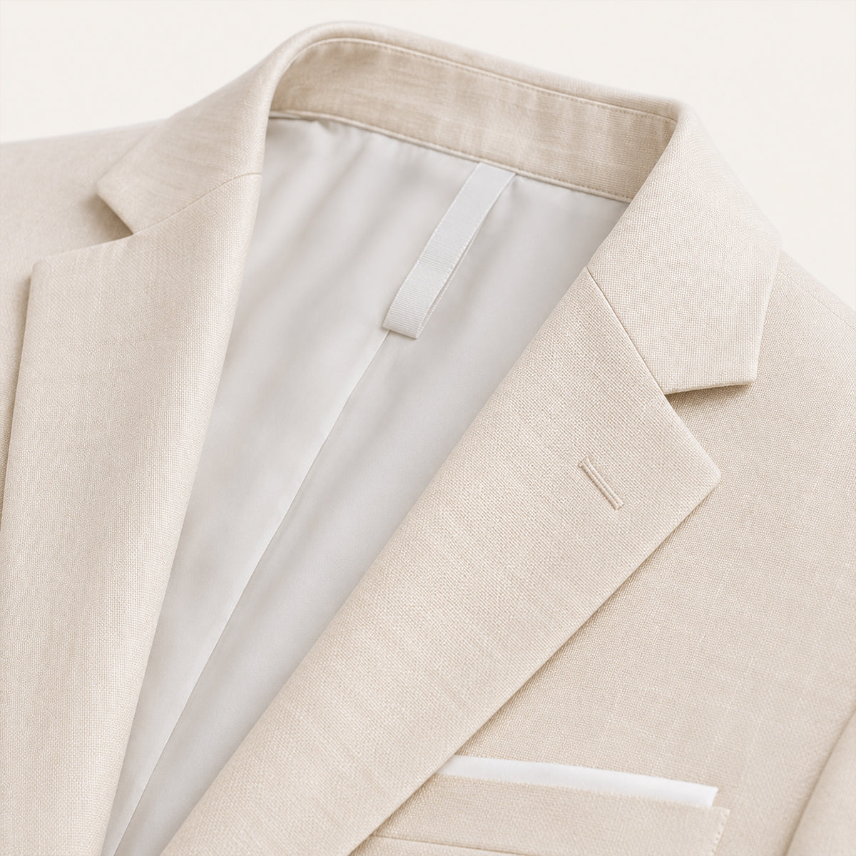 Men's beige blazer detail: notch lapel, breast pocket, and textured fabric