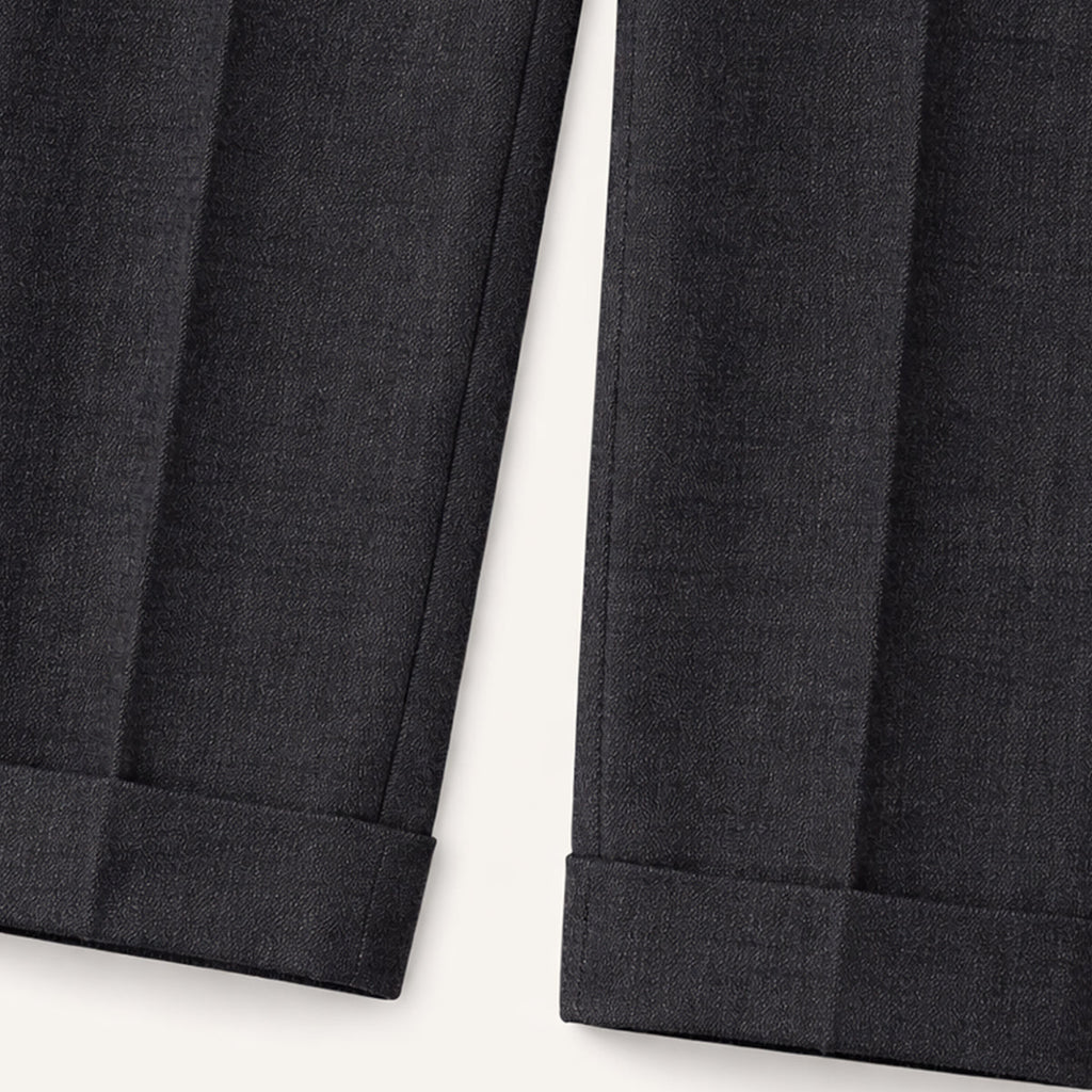 Black pleated tailored trouser hem with straight cuffed finish.