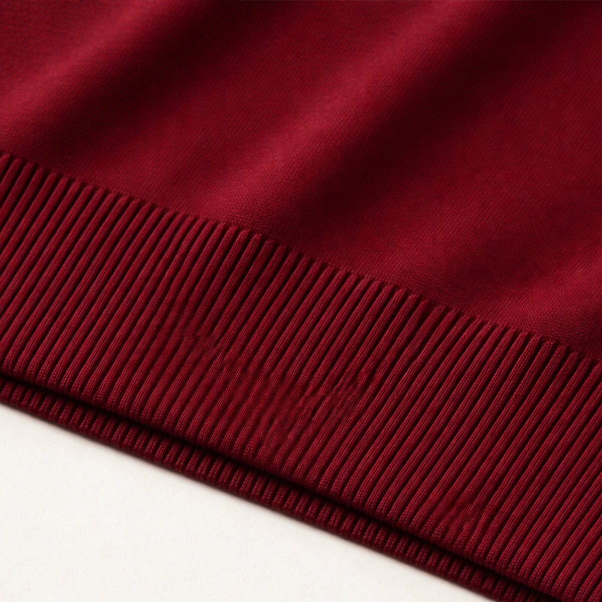 Dark red ribbed hem on a sleeveless knit V-neck sweater vest