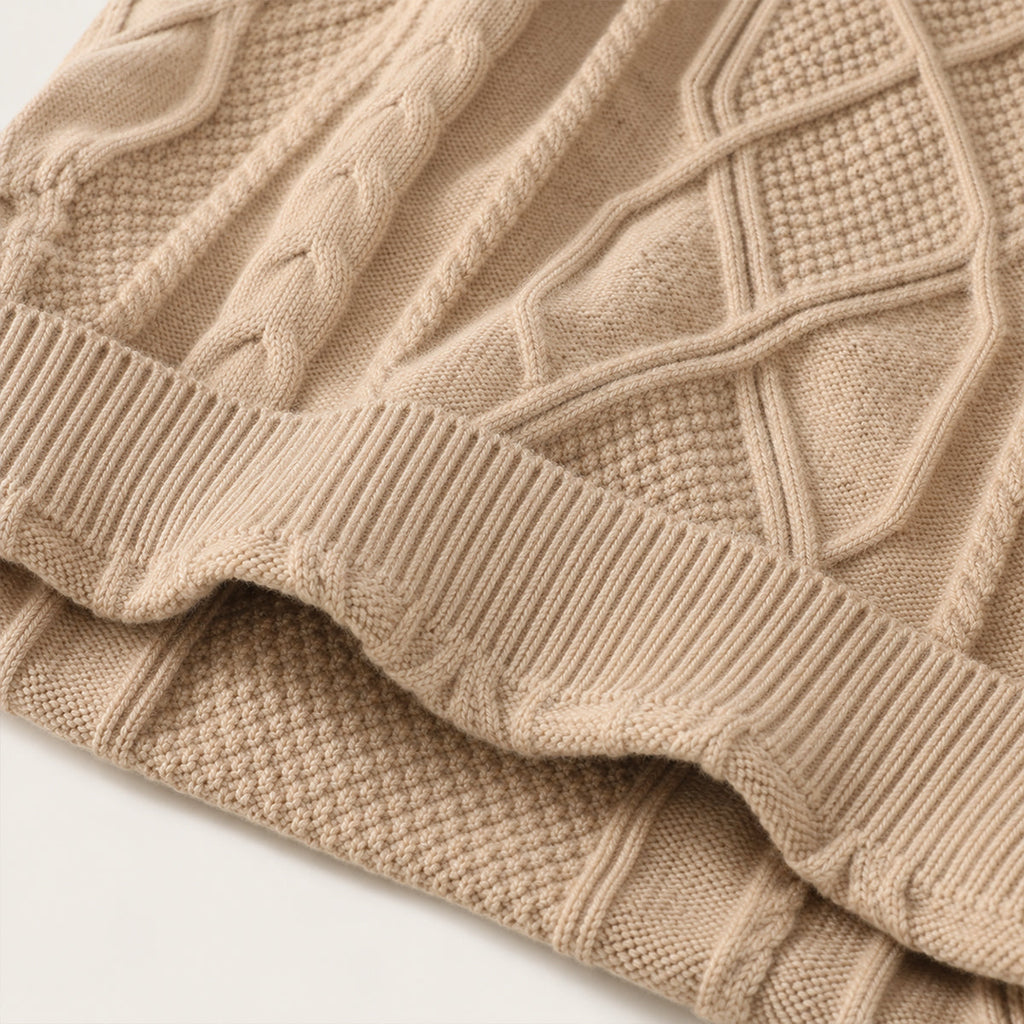 Close-up of beige cable knit sweater cuff and ribbed hem with chunky texture