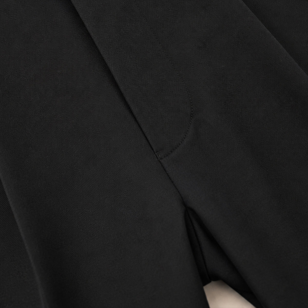 Black dress pants leg with stitched seam and tapered cut
