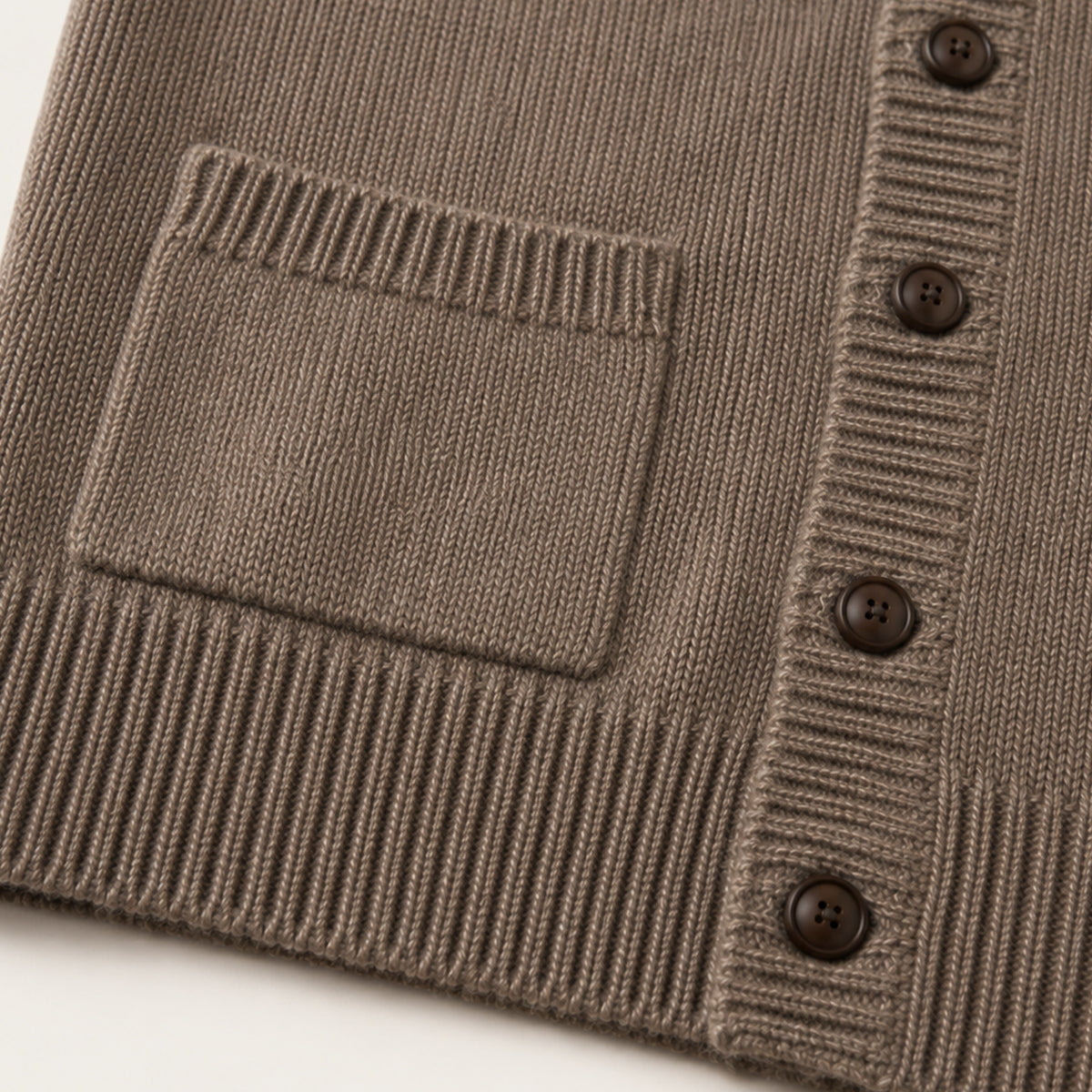 Brown knit vest close-up with patch pocket and button placket on ribbed trim