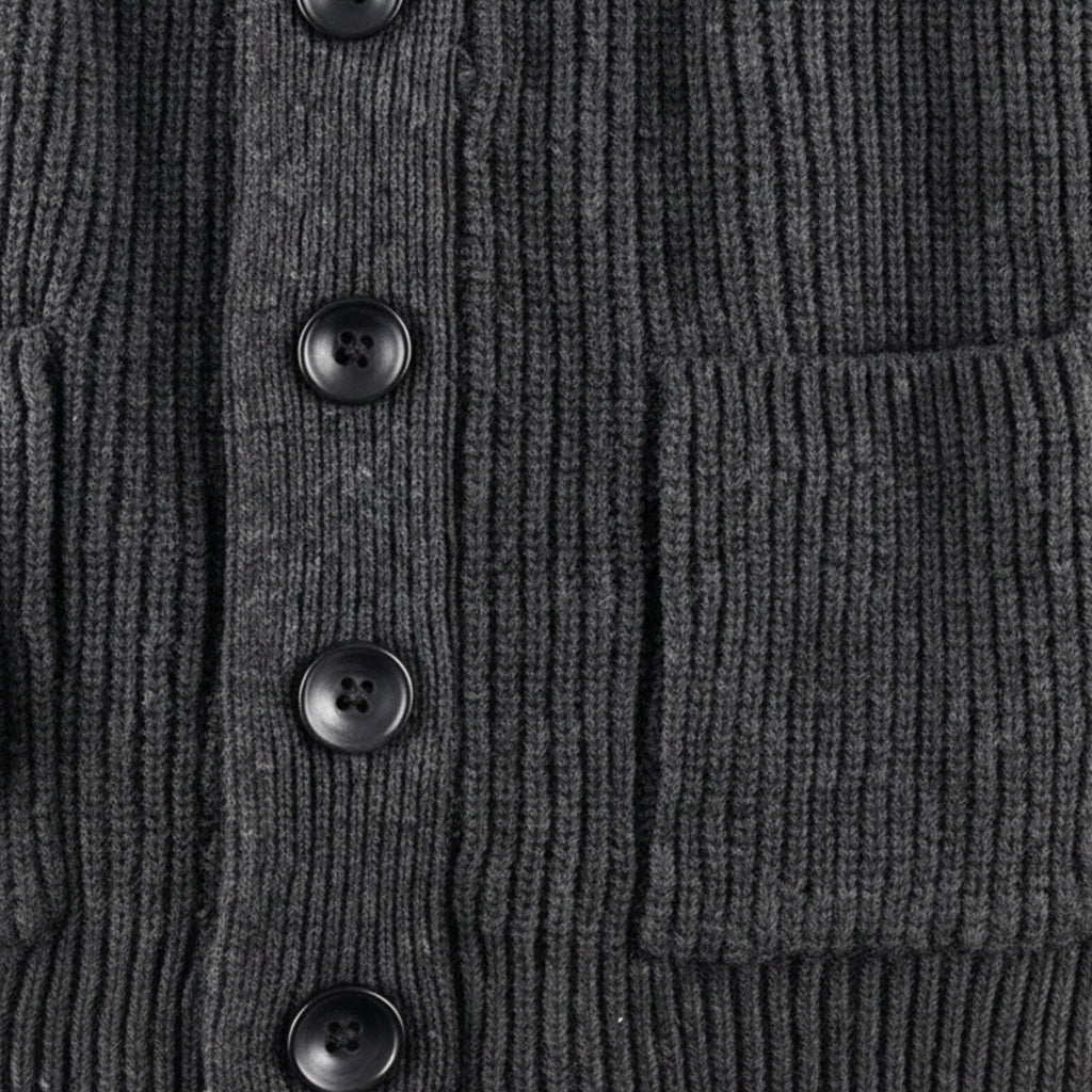 Dark gray chunky knit cardigan detail: black buttons and front patch pocket