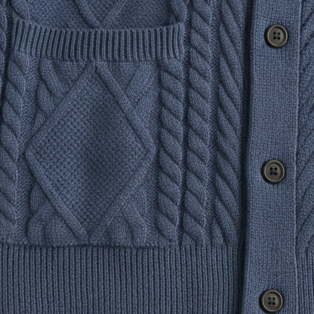 Blue wool cardigan front with cable knit pattern, placket buttons, and pocket