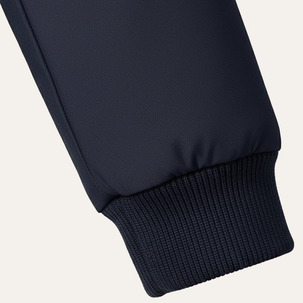 Dark blue jacket sleeve cuff with ribbed knit hem and smooth outer fabric.