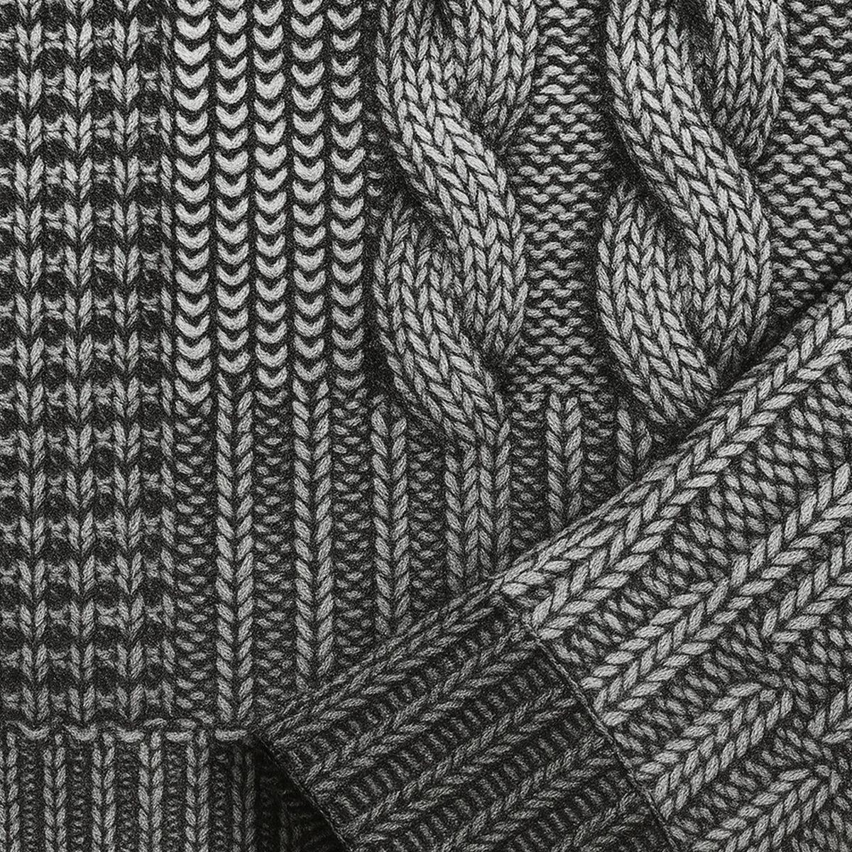 Close-up of dark and light knit cable pattern sweater fabric with ribbed trim