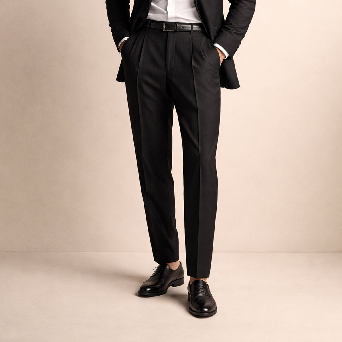 Men's black pleated trousers with crease front, belt loops, worn with leather shoes.