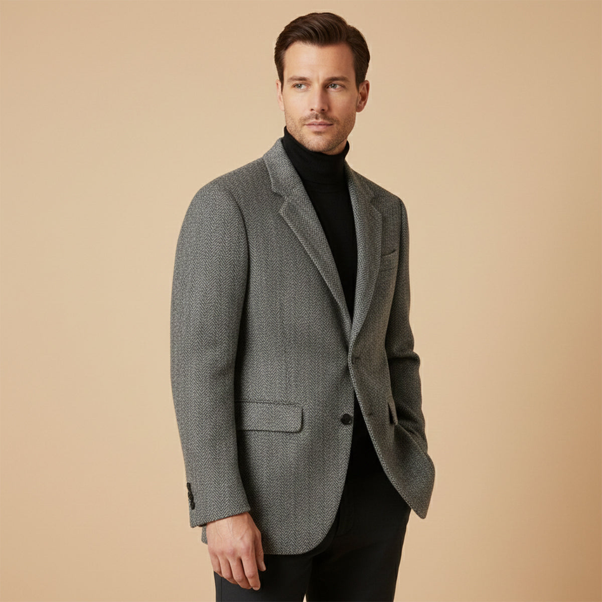 Gray herringbone tweed blazer on model, two-button front and notched lapel.