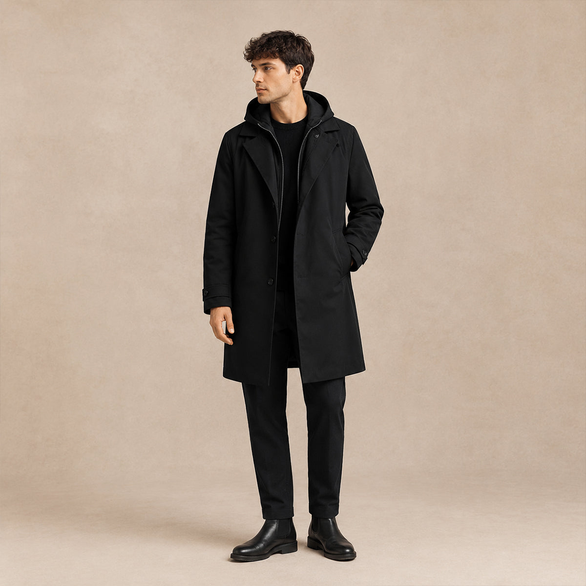 Men's black hooded long parka with front pockets and zip closure, worn over trousers