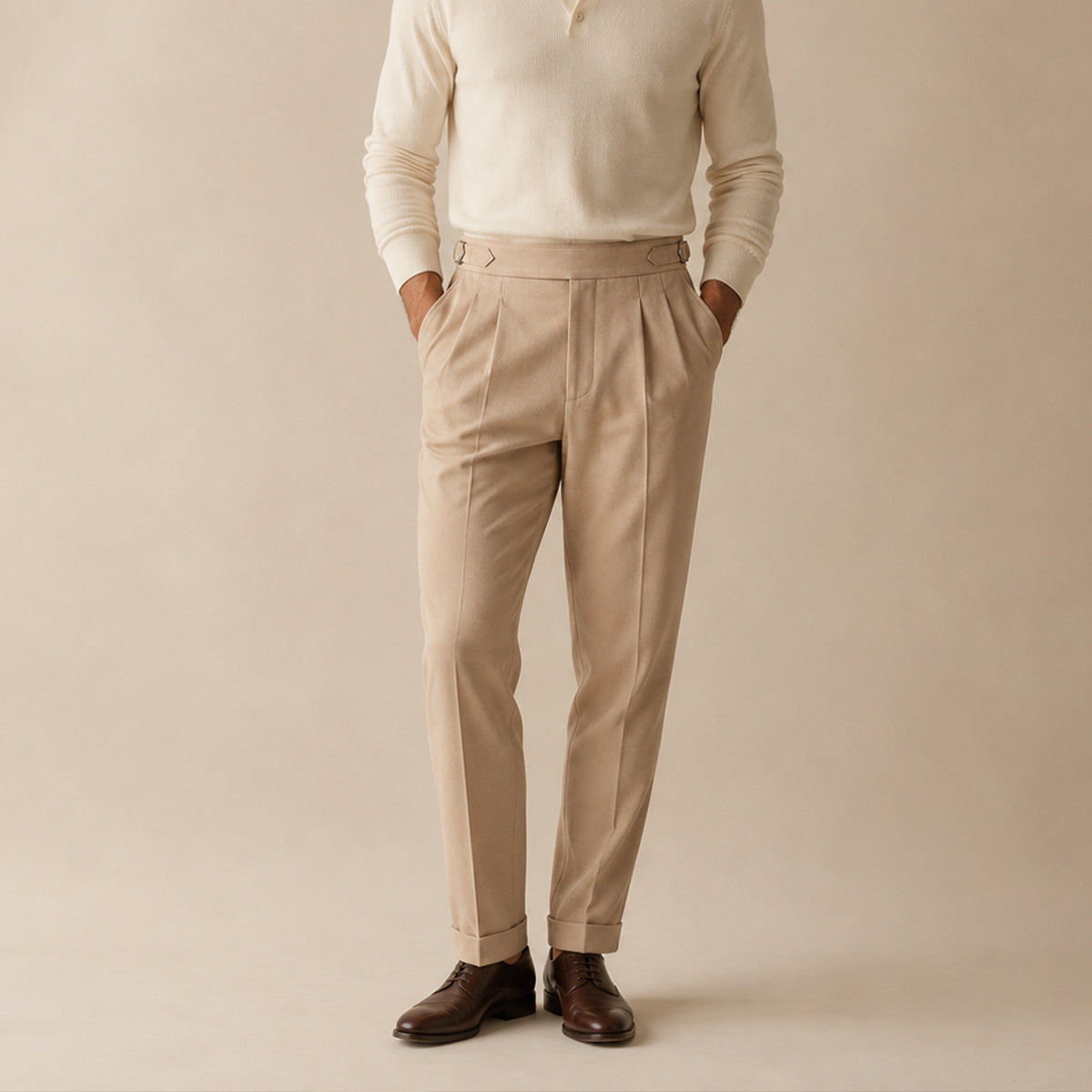 Apricot high-waist double-pleated trousers on model, tapered tailored fit, cuffed hem.