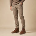 Brown leather ankle boots with lace-up front and rubber outsole, worn with tan pants