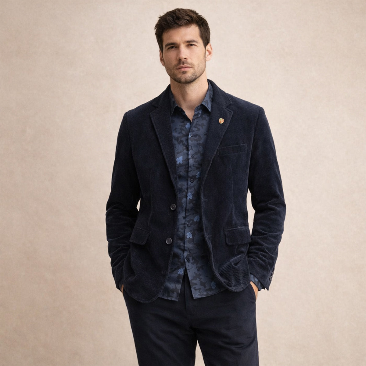 Navy corduroy blazer on model, showing two flap pockets and button cuffs.