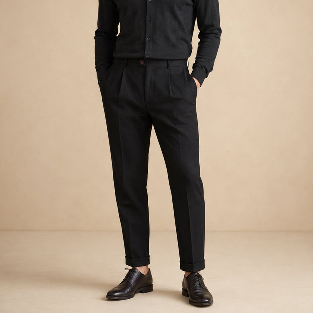 Men’s black classic-fit dress pants on model, flat-front pleats and belt loops