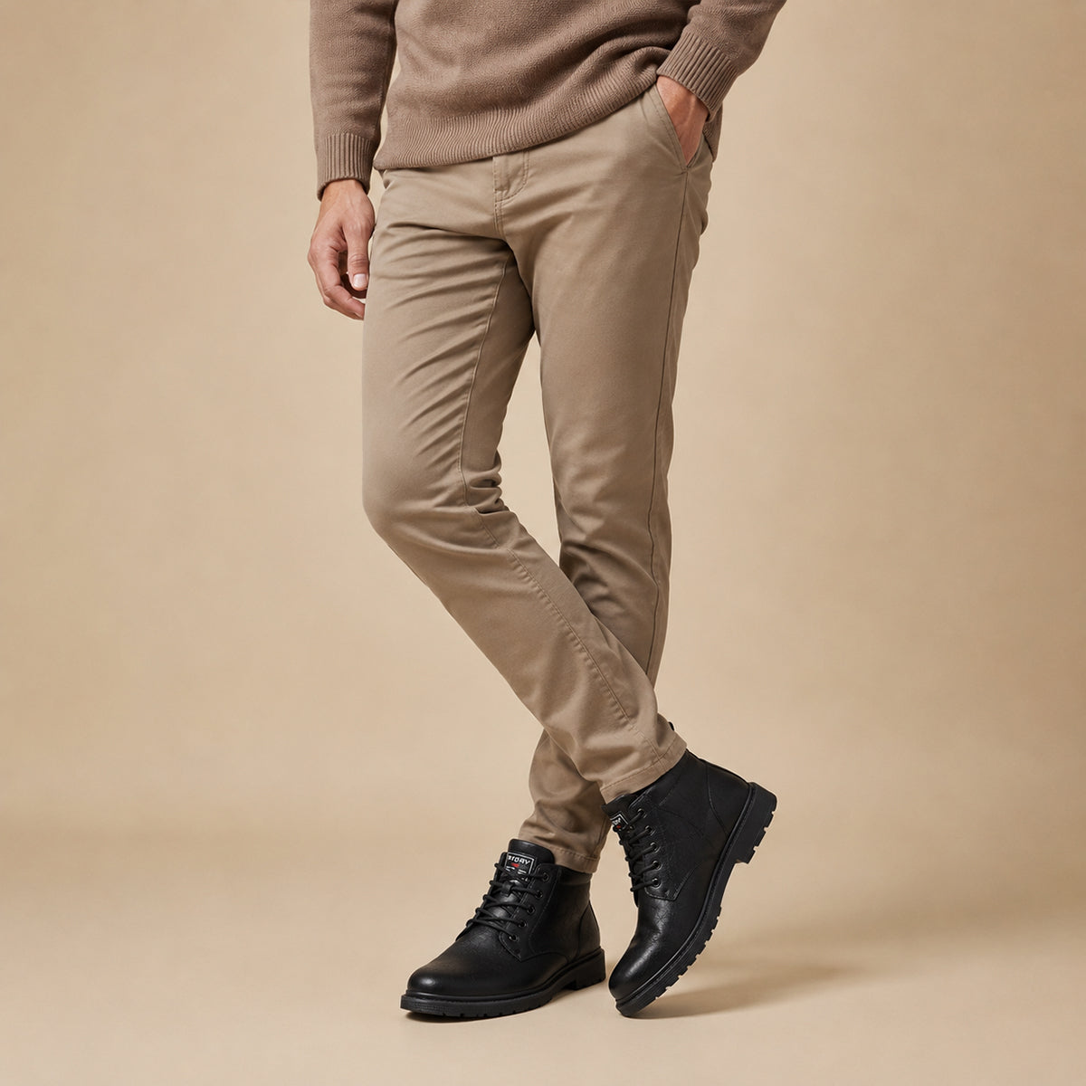 Black leather ankle boots with lace-up front, worn with tan pants and rugged sole