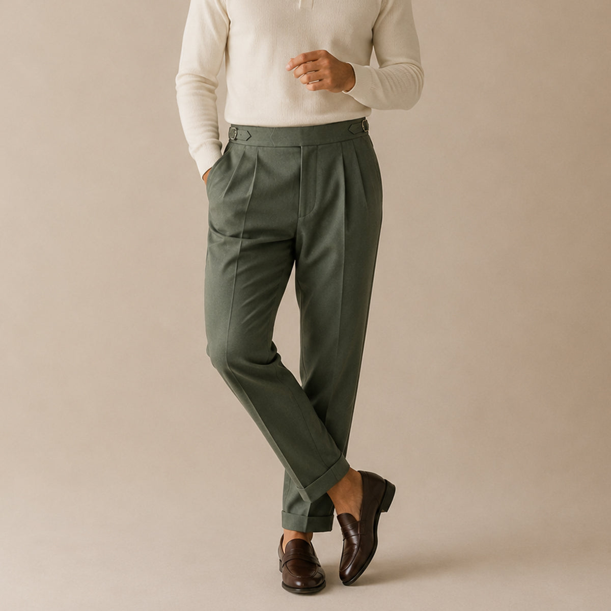 Dark green high-waist double-pleated trousers on model, tailored legs and cuffed hem.