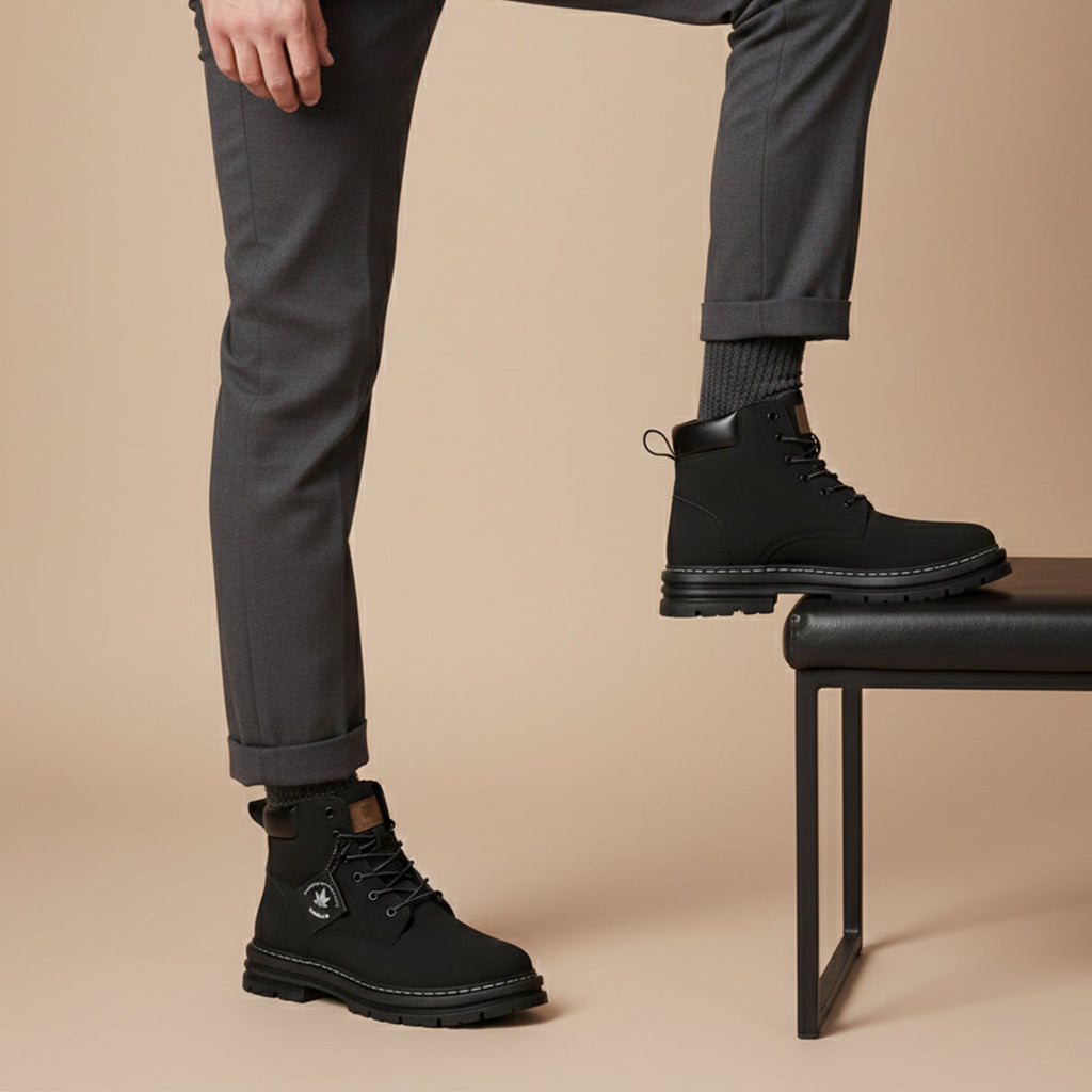 Men's black fur-lined snow boots with lace-up styling, worn with rolled pant cuffs