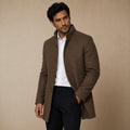 Men's brown wool coat worn open over a shirt, showing button placket and side pockets.
