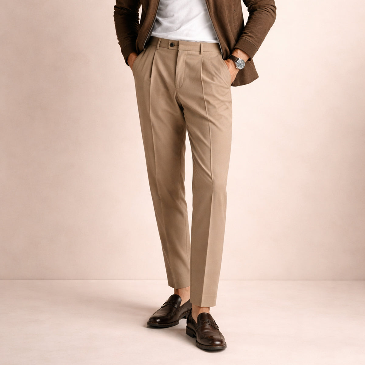 Men's beige pleated trousers with crease front, belt loops, worn with leather shoes.