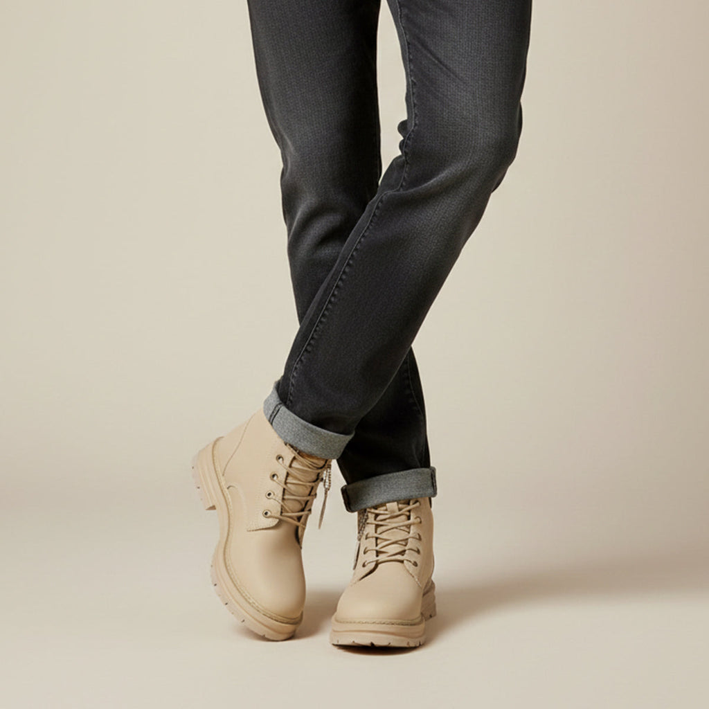 Men's beige fur-lined snow boots with lace-up closure, worn with dark pants and cuffs