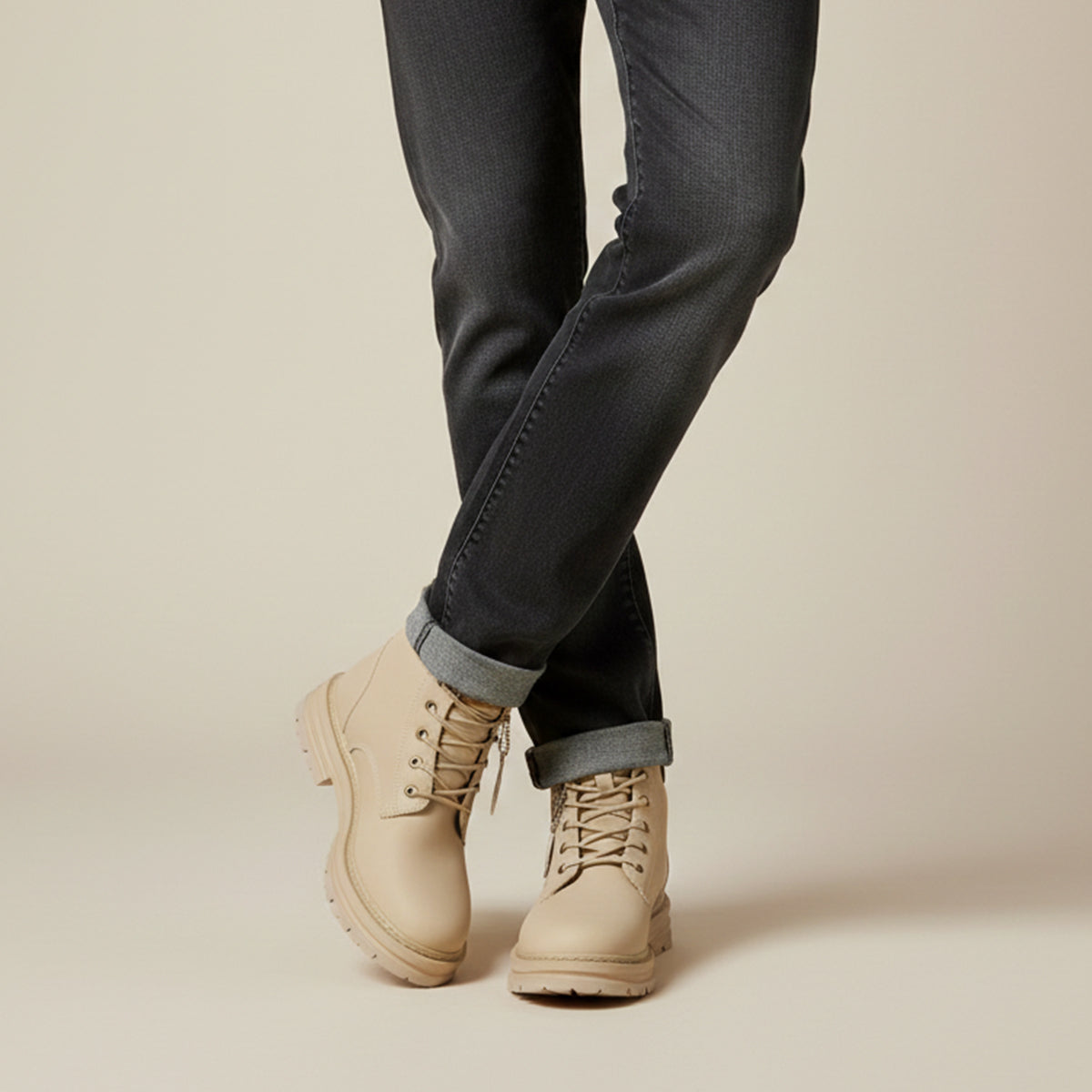Men's beige fur-lined snow boots with lace-up closure, worn with dark pants and cuffs