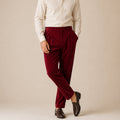 Men's burgundy velvet straight-fit pants on model with belt loops and tapered legs