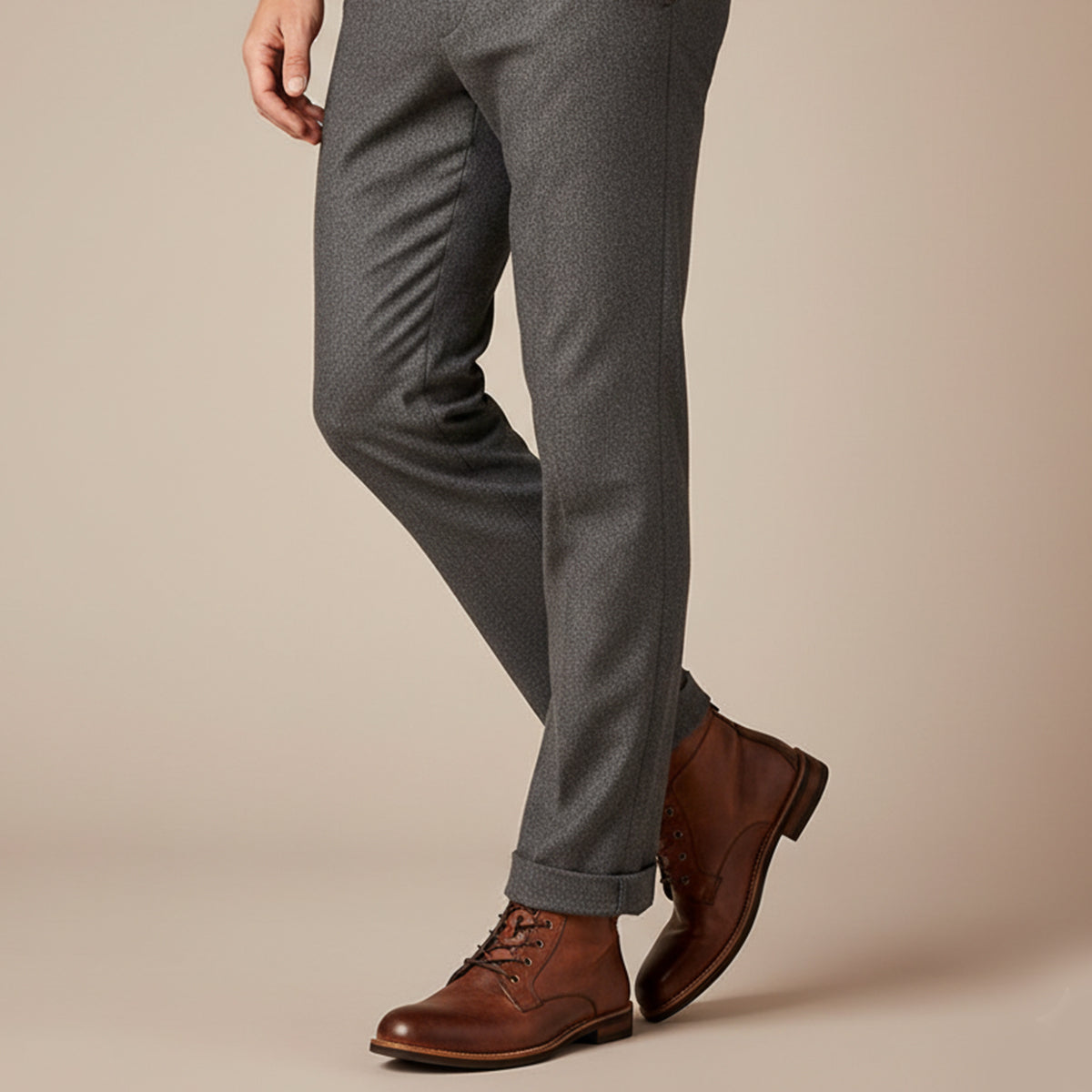 Men's brown lace-up ankle boots paired with dark trousers, low block heel