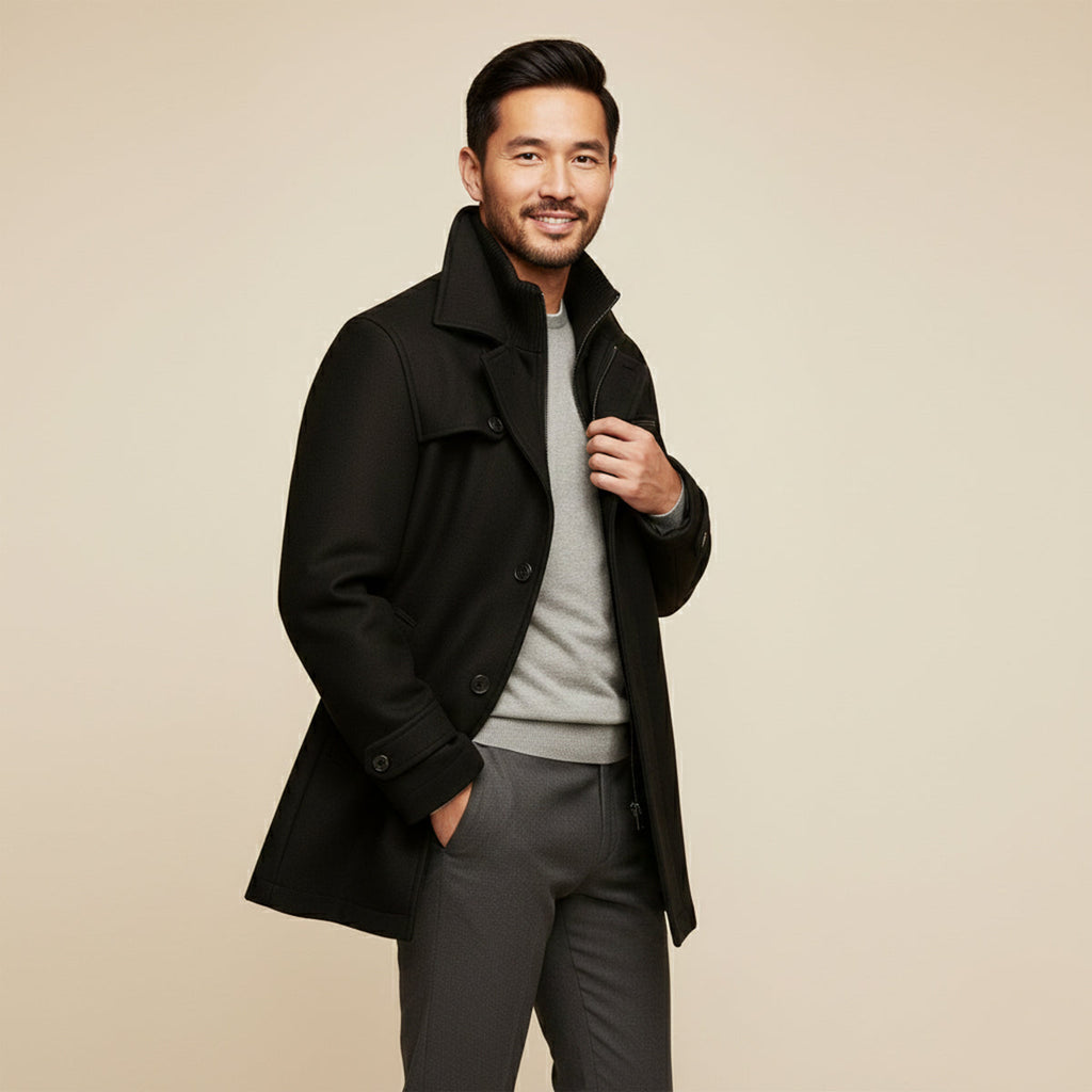 Men's black long jacket worn open, showing stand collar and buttoned front